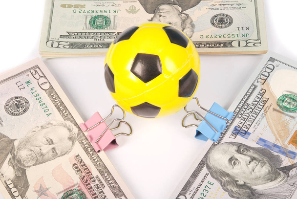 Yellow soccer ball on money. Abstract money background isolated on white - Photo, Image