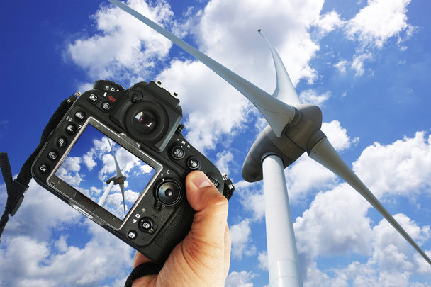 Freelancer fotograaf met Dslr camera nemen foto van windturbine in een zonnige dag - Foto, afbeelding