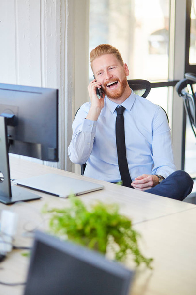 Young businessman in the office talking over mobile phone - Photo, image