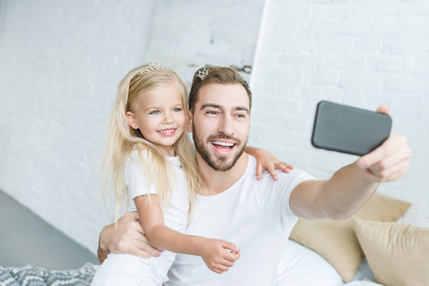 happy father and daughter taking selfie with smartphone at home - Foto, immagini