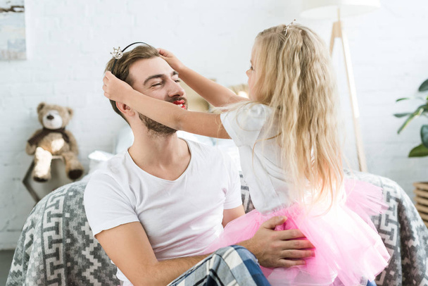 cute little daughter in pink tutu skirt wearing headband with crown to happy father  - Photo, Image
