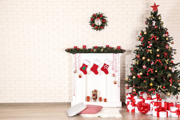 White decorated fireplace with christmas tree on brick wall background - Fotoğraf, Görsel