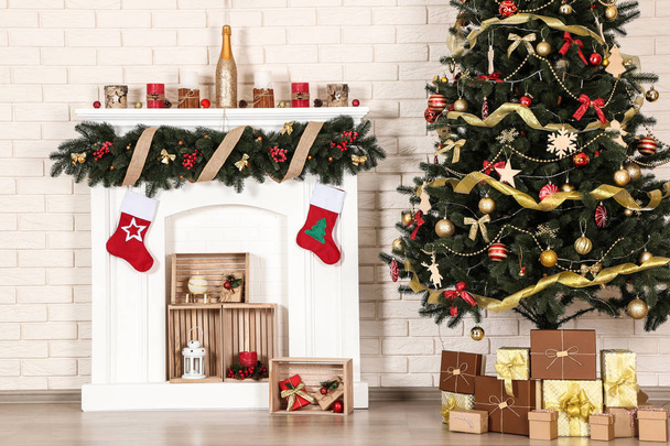 Decorated fireplace near christmas tree on brick wall background - Foto, imagen