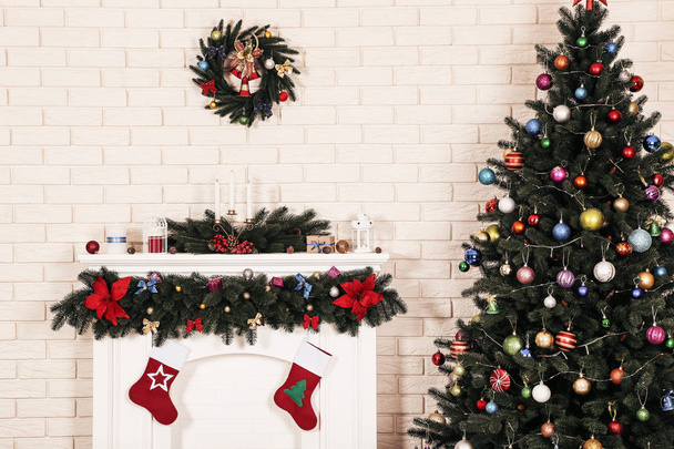 Decorated fireplace near christmas tree on brick wall background - Foto, afbeelding