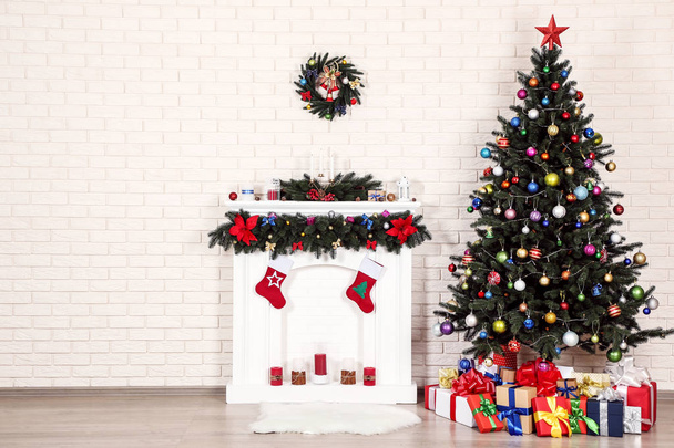 Decorated fireplace near christmas tree on brick wall background - Photo, Image