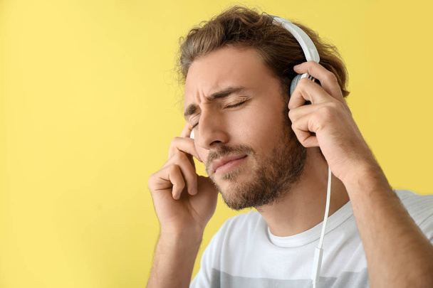 Hombre guapo escuchando música sobre fondo de color
 - Foto, imagen