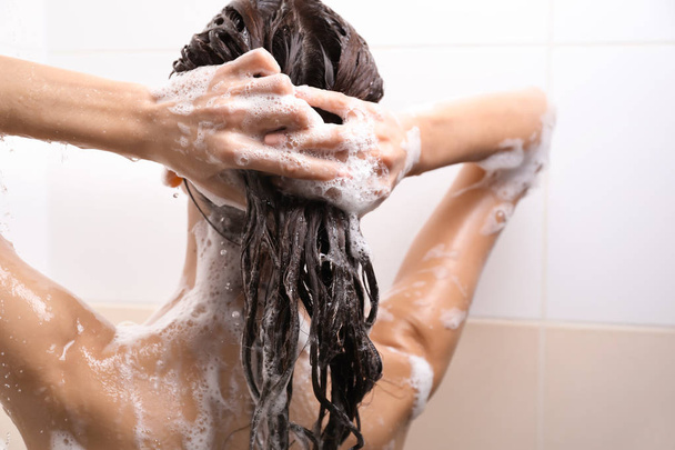 Belle jeune femme prenant une douche dans la salle de bain
 - Photo, image