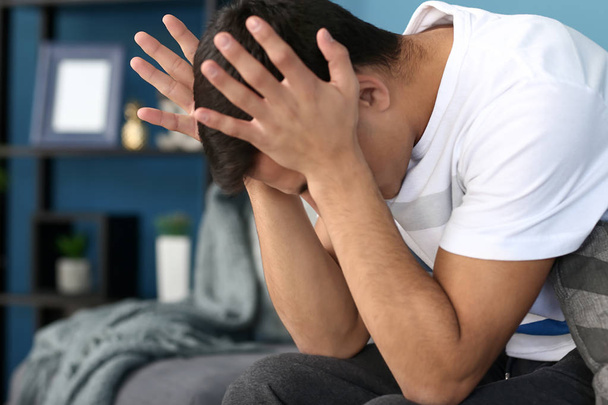Young man suffering from headache at home - Valokuva, kuva