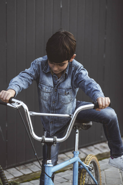Portrait of a boy on a bicycle in park outdoors - Φωτογραφία, εικόνα