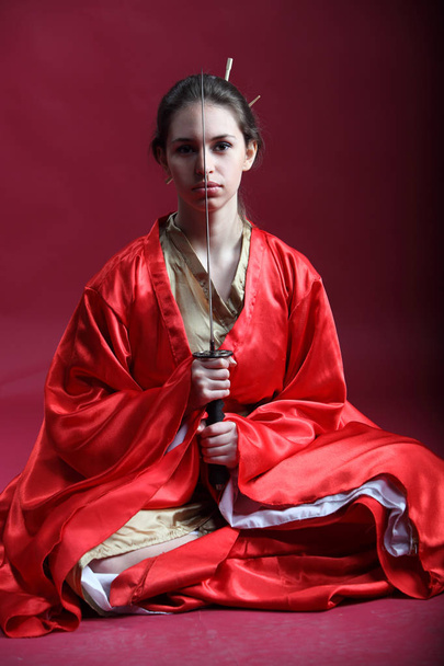 Beautiful brunette girl in a japanese kimono with a katana - Foto, immagini