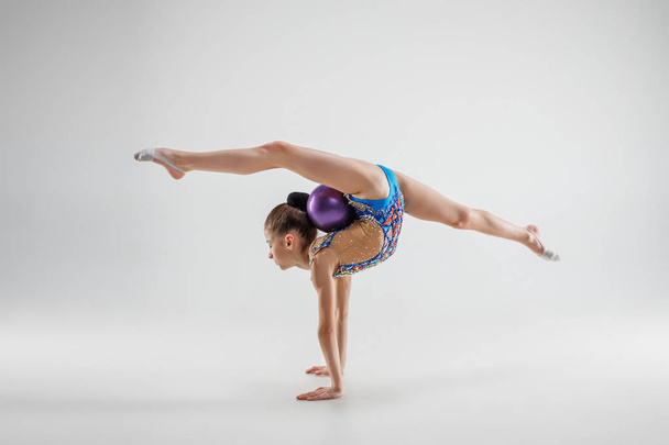 The teenager girl doing gymnastics exercises isolated on white background - Photo, Image