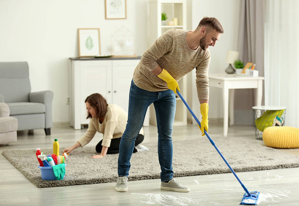 Jovem família limpando seu apartamento
 - Foto, Imagem