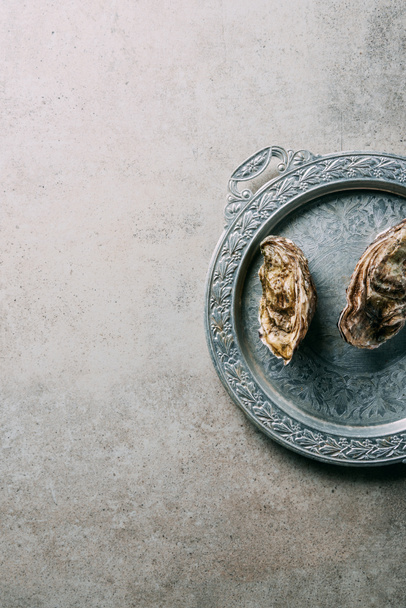 top view of oysters on metal tray on grey tabletop - Zdjęcie, obraz