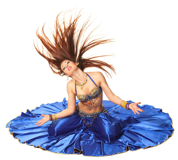 Young beautiful belly dancer in a blue costume - 写真・画像