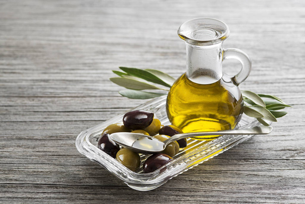 Bottle of Extra virgin healthy Olive oil with fresh olives close up - Photo, image