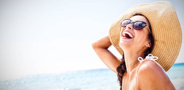 Portrait of smiling woman on the beach on a sunny day - Zdjęcie, obraz