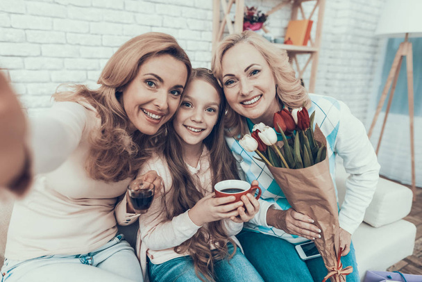 Family Celebrating Birthday and Taking Selfie. Using Smartphone. Happy Family. Mother with Daughter. Smiling Women at Home. Smiling Grandmother. Celebration Concept. Cup of Tea. Cup in Hand. - Foto, Imagen