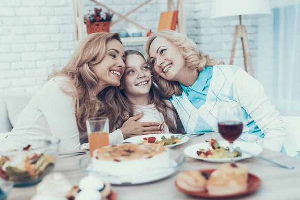 Family Celebrating Daughter's Birthday at Home. Cake on Table. Happy Family. Mother with Daughter. Smiling Women. Smiling Grandmother. Celebration Concept. Glass of Wine. Hugging Together. - Foto, Imagen