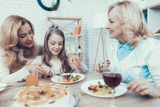 Happy Sitting Family Celebrating Birthday at Home. Cake on Table. Happy Family. Mother with Daughter. Smiling Women. Smiling Grandmother. Celebration Concept. Glass of Wine. Fruits on Plate. - 写真・画像