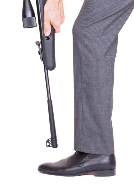 Empresario disparándose en el pie con un rifle
 - Foto, Imagen