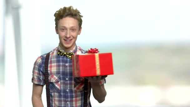 Lächelnder Junge bietet Geschenkbox an. - Filmmaterial, Video