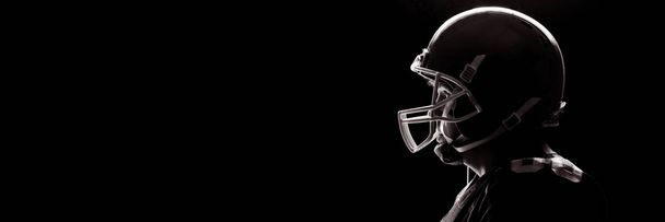 Side view of American football player standing with rugby helmet - Foto, afbeelding