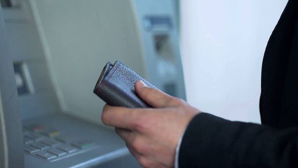Man with wallet typing pin code on ATM to withdraw money and check account - Fotoğraf, Görsel