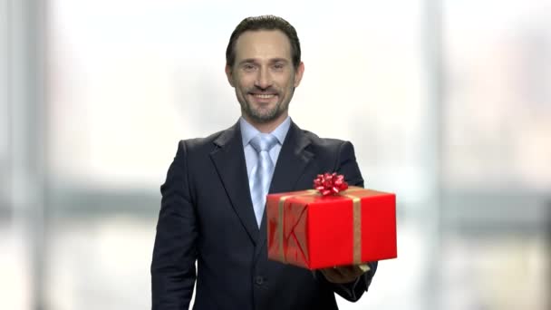 Attractive middle-aged businessman giving gift box. - Footage, Video