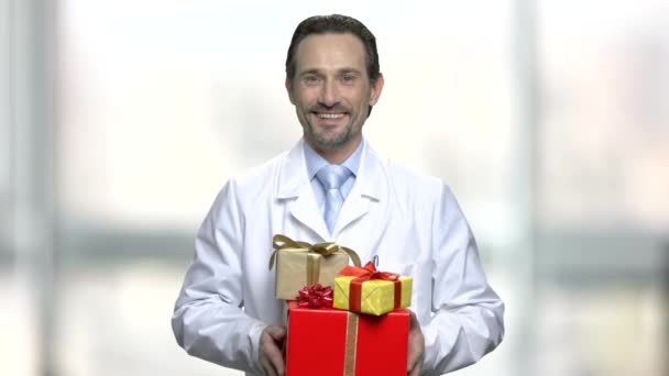 Lachende arts stapel geschenkdozen houden. - Video