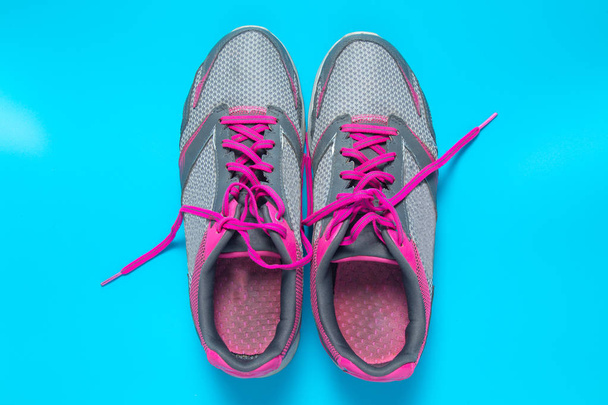 Sport flat lay pink shoes on blue background with copyspace for your text. Concept healthy lifestyle and diet. - Photo, Image