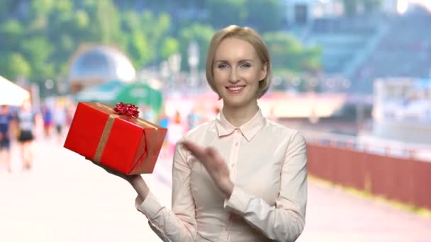 Portret uśmiechniętej kobiety trzymającej pudełko z prezentami. - Materiał filmowy, wideo