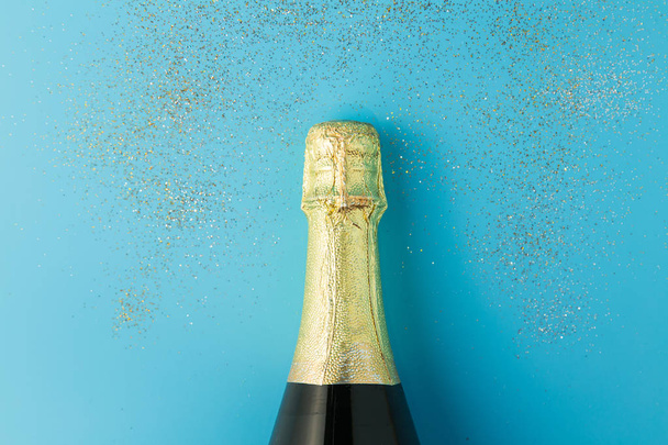 Плоский шар святкування, пляшка шампанського на синьому фоні з блиском
. - Фото, зображення
