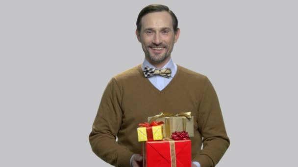 Glimlachende man van middelbare leeftijd geven geschenkdozen. - Video