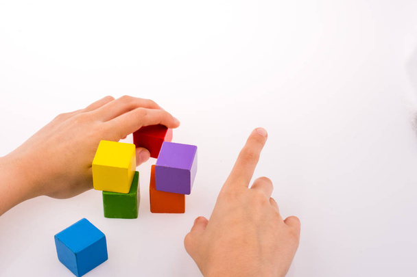 Hand playing with colorful cubes on a white background - Fotó, kép