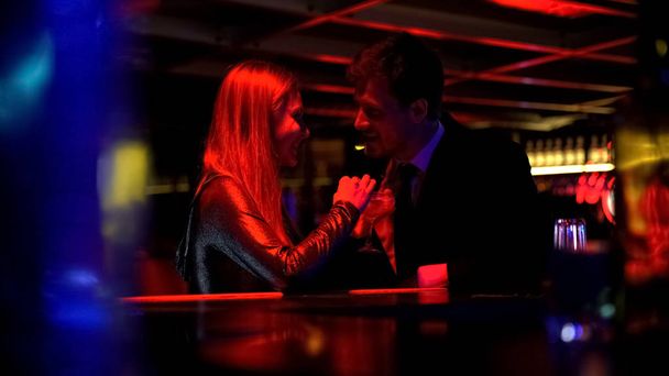 Happy beautiful couple drinking cocktails and flirting in nightclub, romance  - Zdjęcie, obraz