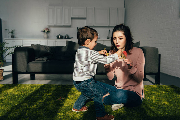 madre e piccolo figlio giocare dinosauri giocattolo in soggiorno a casa
 - Foto, immagini
