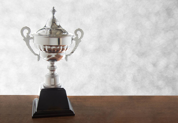 Trofeo de plata sobre mesa de madera aislada sobre fondo blanco. Ganar premios con espacio de copia
. - Foto, Imagen