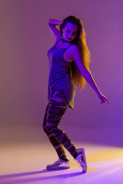 Modern style dancer posing on studio background. Color filters - Foto, afbeelding