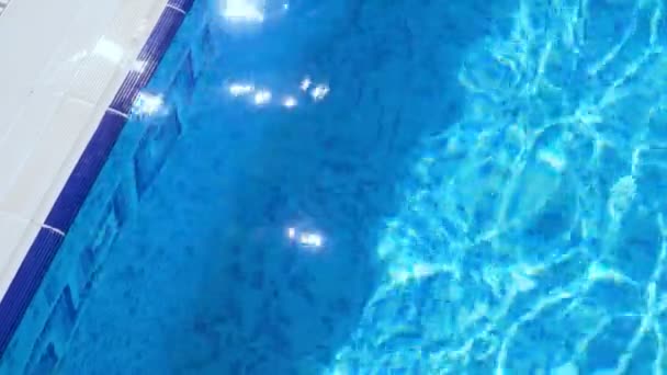 Zvlnění na modrou vodu v bazénu s odrazy světla. - Záběry, video