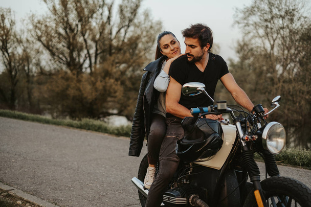 Mann fährt Motorrad mit Freundin hinter sich und lächelt - Foto, Bild
