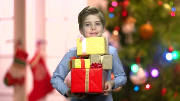 Boy with Christmas gifts on blurred background. - Πλάνα, βίντεο