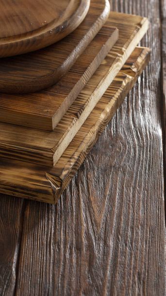 enfoque selectivo de pila de diferentes tablas de cortar de madera en la vieja mesa de madera
 - Foto, Imagen