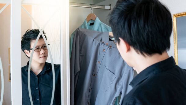 Ázsiai ember választotta inget a szekrényben - Fotó, kép