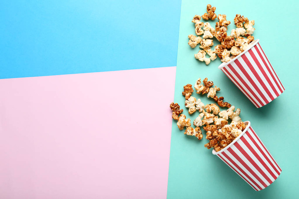 Caramel popcorn in paper cups on colorful background - 写真・画像