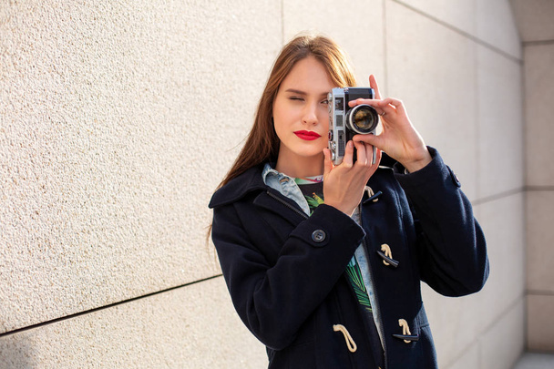 hipster szczęśliwy dziewczyna co zdjęcie aparatem retro na miasto ulica - Zdjęcie, obraz