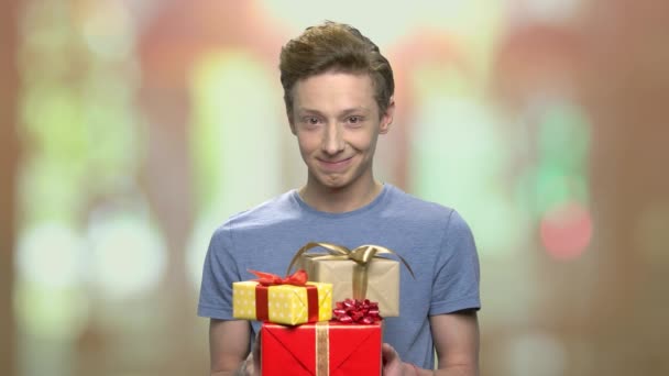 Tiener jongen presenteert geschenkdozen. - Video