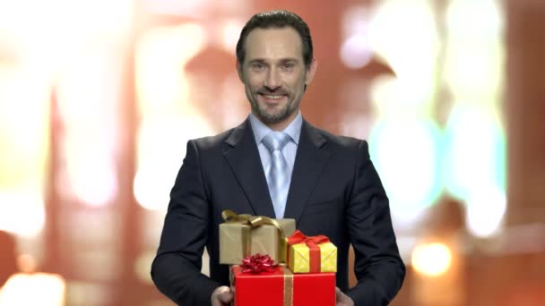 Porträt eines attraktiven Geschäftsmannes mit Geschenkschachteln. - Filmmaterial, Video