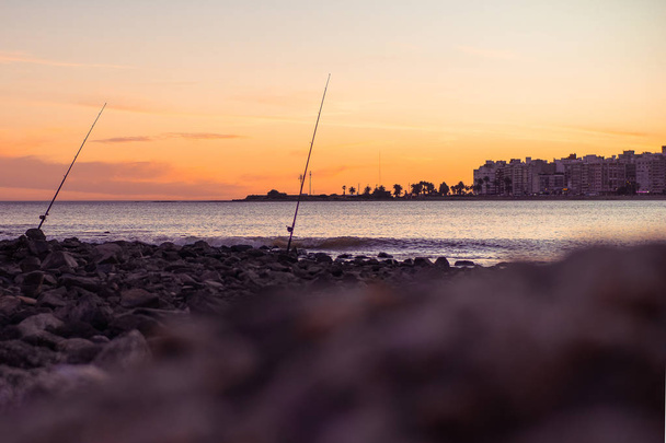 Cañas de pescar con puesta de sol
 - Foto, Imagen