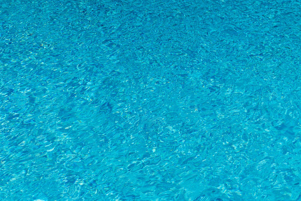 Mavi su yüzme havuzu arka planda. Güneş yansıması ile yüzme havuzunda su dalgalanma. Mavi yüzme havuzu su ayrıntı et kalınlığı ile yivli. - Fotoğraf, Görsel