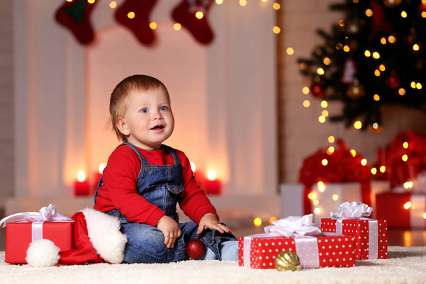 Little boy sitting on floor with christmas gift boxes - Zdjęcie, obraz